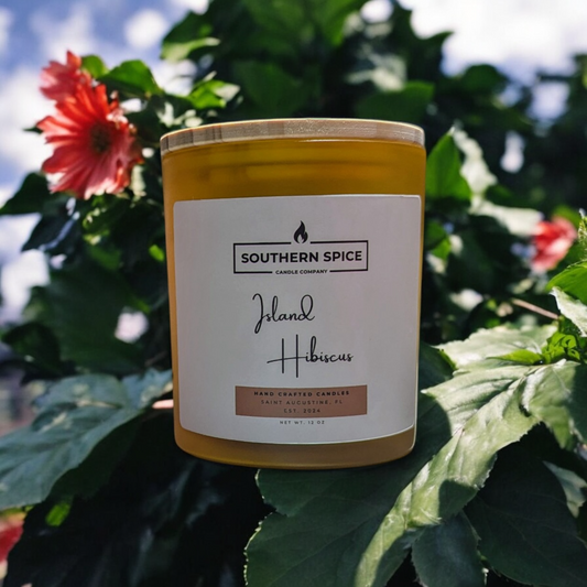 Island Hibiscus candle with hibiscus plant in background